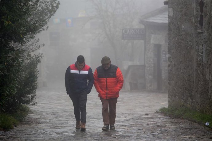 Dos hombres caminan entre la niebla en la aldea prerromana de O Cebreiro, Concello de Pedrafita do Cebreiro, Lugo, Galicia (España). A Montaña lucense ha registrado las primeras nevadas en las  zonas más altas de Cervantes y Pedrafita (Lugo), donde han 