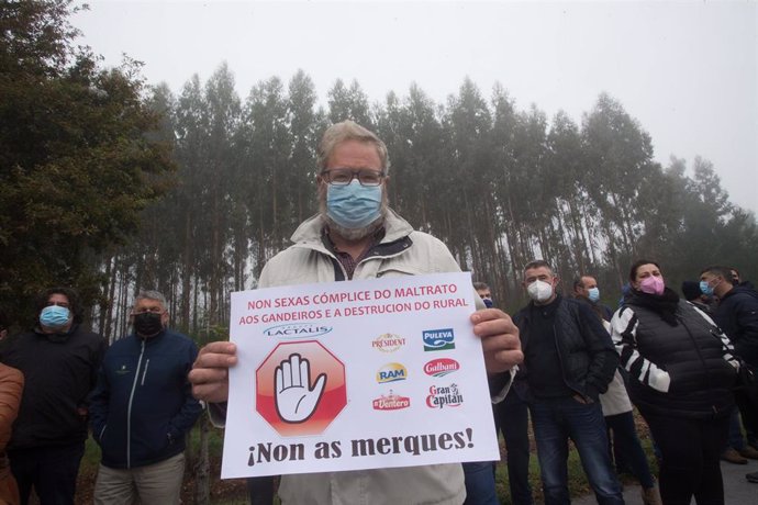 Una persona sostiene una pancarta en una concentración del sector lácteo para exigir "precios justos" para la producción de leche, frente a la factoría de Lactalis, a 11 de noviembre de 2021, en Vilalba, Lugo, Galicia, (España). El objetivo de esta prot