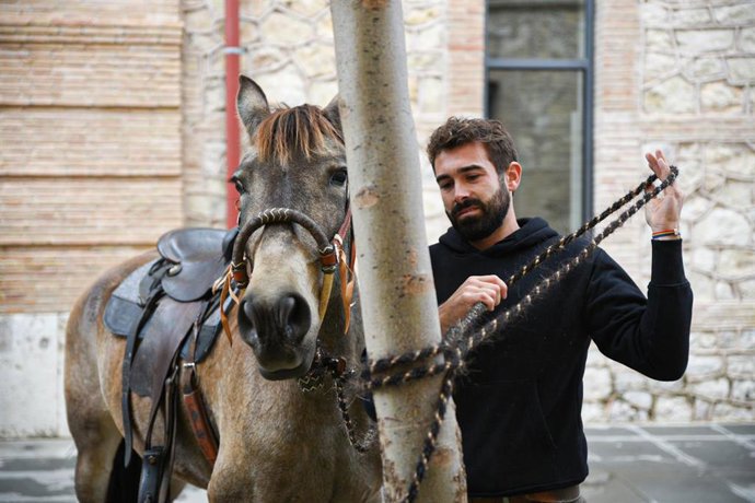 El joven ganadero Rubén Llata ata a su caballo, tras llegar a la Ciutat Administrativa Nou d'Octubre para pedir la prórroga de la concesión de terrenos en Tous (Valencia) para que  sus más de cien caballos puedan seguir pastando allí