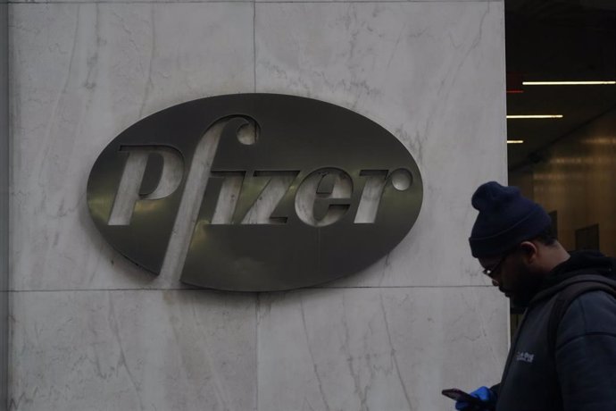 Archivo - 11 December 2020, US, New York: A man with a face mask walks past the headquarters of Pfizer Inc.