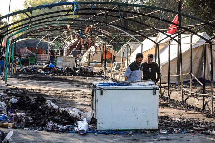 06 November 2021, Iraq, Baghdad: People inspect burned out tents outside Baghdad's Green Zone following the clashes between anti-riot police and supporters of pro-Iran Shiite militias who had camped outside Baghdad's Green Zone. Photo: Ameer Al Mohammed
