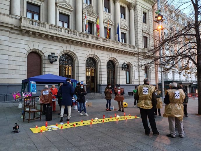 Miembros de ADICAE en la preparación de la 'perfomance' que han realizado en la plaza de España de Zaragoza, en protesta por la subida de la luz.