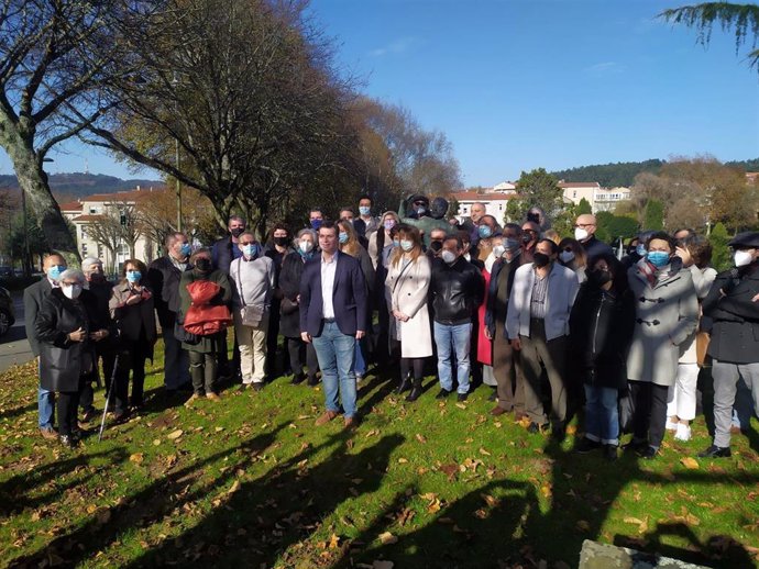 El secretario xeral saliente del PSdeG, Gonzalo Caballero, junto a militantes y cargo del partido ante la estatuta de Pablo Iglesias en el barrio de Vite de Santiago de Compostela