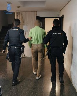 Imagen del detenido como presunto autor de dos robos en locales de restauración y un hurto en un hotel de Playa de Palma, escoltado por dos agentes.