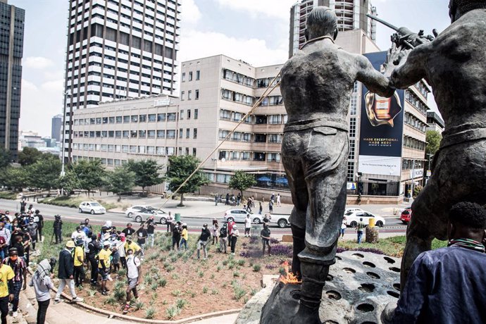 Archivo - 12 March 2021, South Africa, Johannesburg: Students attempt to fall a statue during a demonstration against the financial exclusion of some students of the University of the Witwatersrand. Photo: Thabo Jaiyesimi/SOPA Images via ZUMA Wire/dpa
