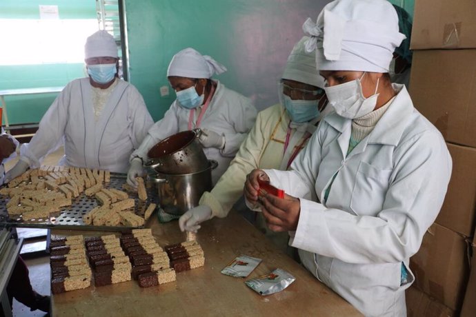 Las mujeres trabajan con las barras de quinua