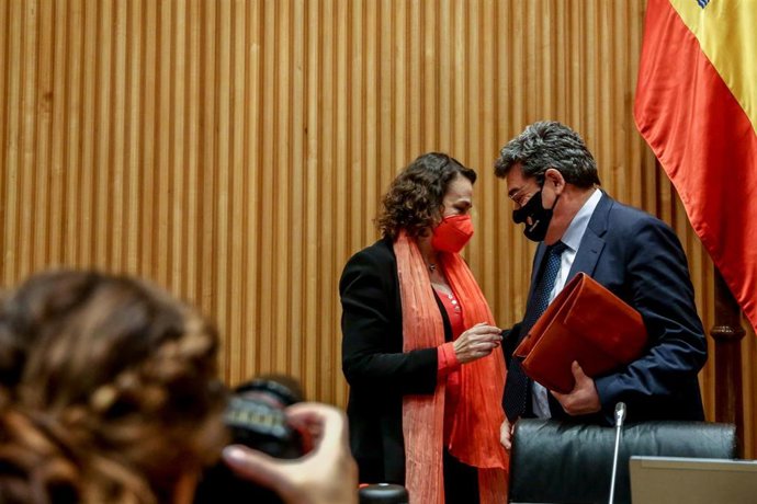 El ministro de Inclusión, Seguridad Social y Migraciones, José Luis Escrivá (d), habla con la presidenta de la Comisión de Seguimiento y Evaluación de los Acuerdos del Pacto de Toledo, Magdalena Valerio (i), antes de comparecer en la comisió