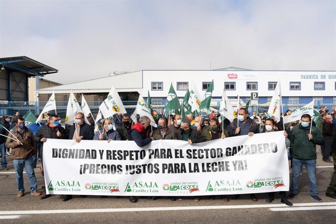 Varias personas con una pancarta en la que se lee: 'Dignidad y respeto para el sector ganadero', participan en una concentración para reclamar un precio justo de la leche de vaca para el ganadero, a las puertas de Lactalis, a 9 de noviembre de 2021, en 