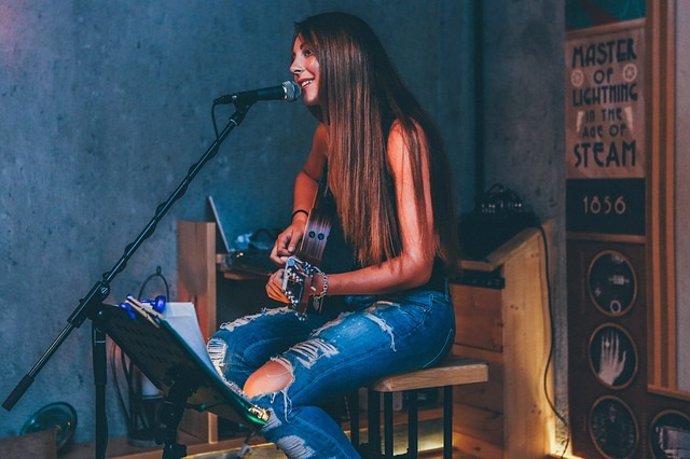 Mujer cantando y tocando la guitarra