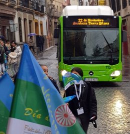 Archivo - Dos jóvenes con la bandera gitana ante un autobús de Aucorsa con el lema alusivo al Día de los Gitanos de Andalucía, en una imagen de archivo.