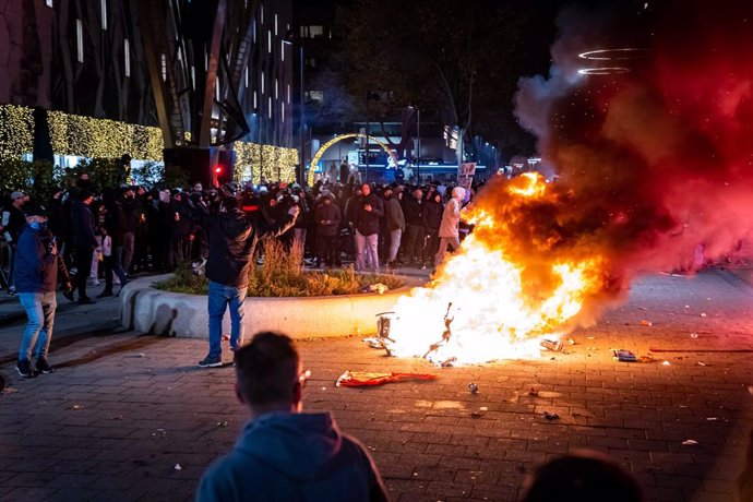 19 November 2021, Netherlands, Rotterdam: A scooter was set on fire during a protest against the 2G policy at the Coolsingel. Violent riots broke out in the Dutch port city of Rotterdam during a demonstration by hundreds of people against stricter anti-