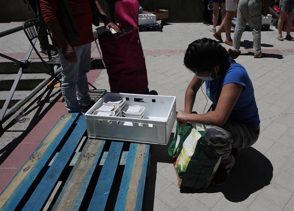 Archivo - Una mujer recoge productos a las puertas de una parroquia durante la pandemia.