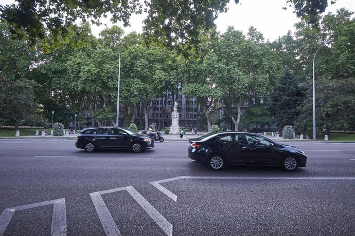 Archivo - Vehículos circulando por el Paseo del Prado con la Fuente de Apolo al fondo.