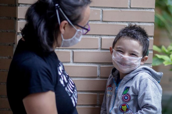 Archivo - El pequeño Hugo, sordo profundo y usuario de dos implantes cocleares, con una mascarilla transparente certificada con la que se comunica con su madre