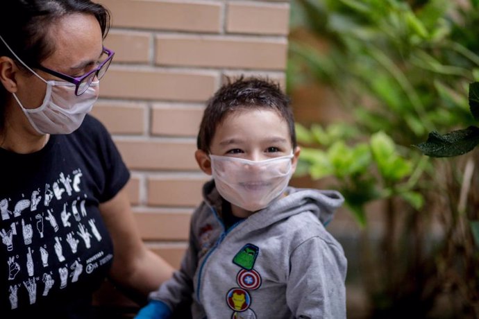 Archivo - El pequeño Hugo Romero, sordo profundo y usuario de 2 implantes cocleares, utiliza una mascarilla transparente certificada -pero no homologada por el Ministerio de Sanidad- con la que se comunica con su madre Elena Alvarez, en Villaverde, Madr