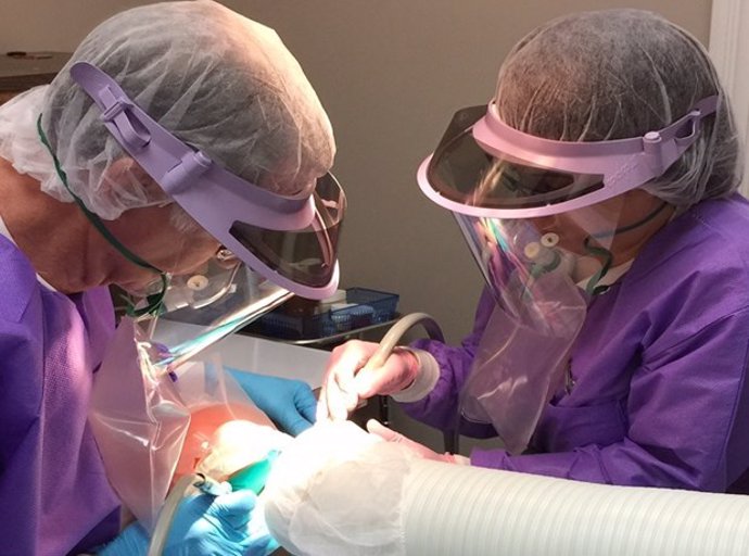Dentist and assistant utilizing the IAOMTs Safe Mercury Amalgam Removal Technique (SMART), which dentists can now learn in a course that is being offered in multiple languages.