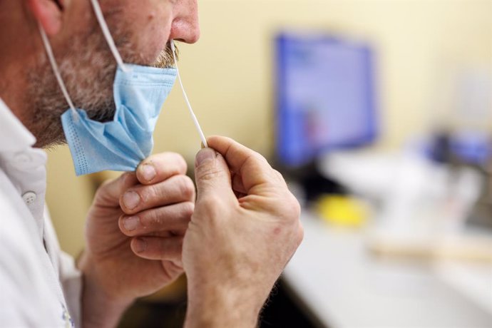 22 November 2021, Bavaria, Heimstetten: An employee takes a swab from his nose for a Coronavirus quick test in the office of the production manager in a production building of the Traublinger bakery and confectionery chain. Photo: Matthias Balk/dpa