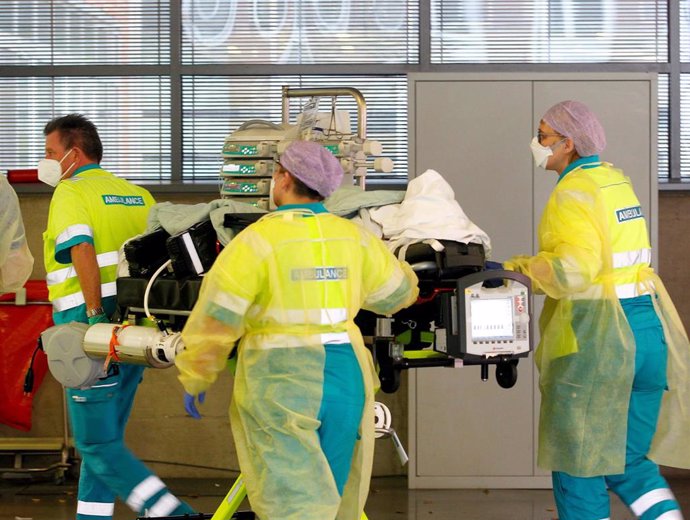 23 November 2021, North Rhine-Westphalia, Bochum: The crew of a Dutch ambulance brings a Covid-19 patient from Rotterdam to BG University Hospital Bochum. The patient had been treated in the intensive care unit in Rotterdam. Photo: Roland Weihrauch/dpa