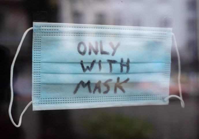 09 November 2021, Berlin: A mask with the inscription "Only with Mask" is seen on the window of a restaurant in Friedrichshain.