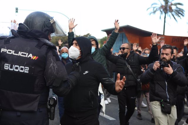 Manifestantes con las manos alzadas ante la policía que han intervenido durante los disturbios producidos por los  estudiantes que se han manifestado en apoyo al sector del metal este martes en Cádiz.