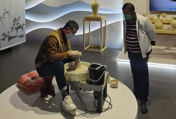 An artist shows plastic forming, one of porcelain making skills, in Gao'an Yuan Dynasty blue and white porcelain Museum, Nov. 20, 2021.