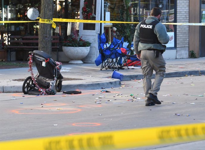 22 November 2021, US, Waukesha: A police officer investigates the scene in downtown Waukesha after a SUV vehicle plowed into the Waukesha Christmas parade in Wisconsin. Several people were dead and dozens injured. Photo: Mark Hertzberg/ZUMA Press Wire/d