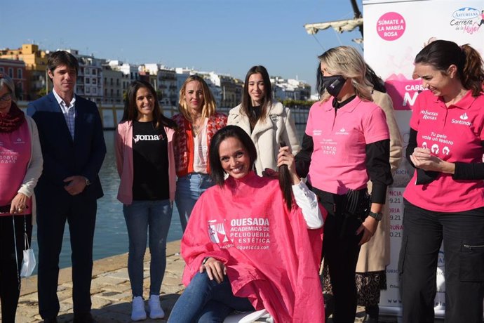 Durante el acto de presentación de la Carrera de la Mujer que impulsa el Ayuntamiento de Sevilla, una voluntaria se ha cortado el pelo para llamar la atención sobre el componente solidario del evento.