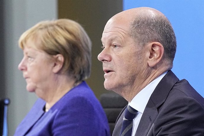 18 November 2021, Berlin: Acting German Chancellor Angela Merkel (L), and Olaf Scholz, Acting German Minister of Finance, take part in a press conference at the Federal Chancellery following the Chancellor's video conference with the Minister Presidents