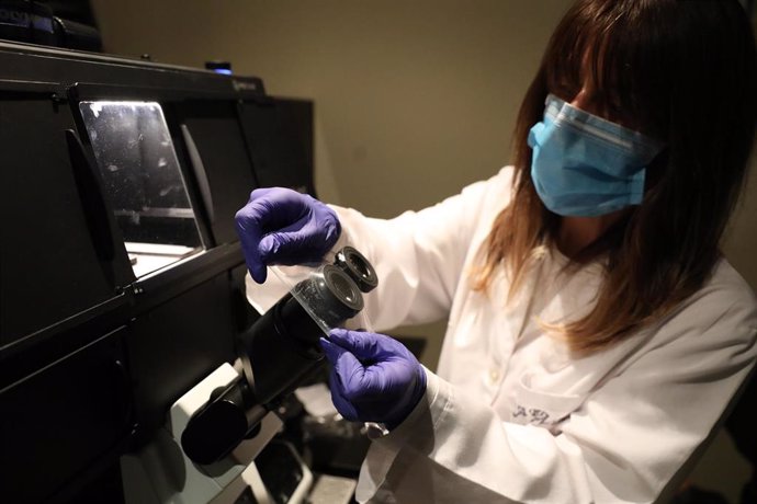 Archivo - Una bióloga del Centro de Biología Molecular Severo Ochoa en el Campus de Cantoblanco de la Universidad Autónoma protege las lentes de un microscopio con plástico.