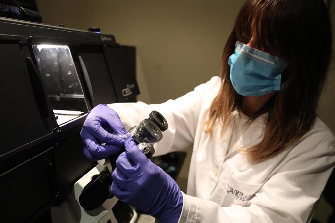 Archivo - Una bióloga del Centro de Biología Molecular Severo Ochoa en el Campus de Cantoblanco de la Universidad Autónoma protege las lentes de un microscopio con plástico 