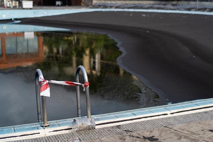Cinta colocada en la escalerilla de la piscina del hotel La Palma & Teneguía Princess cubierta de ceniza