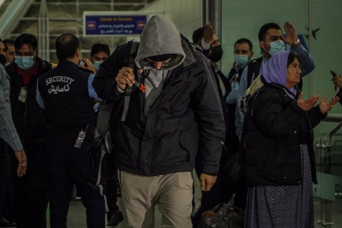18 November 2021, Iraq, Erbil: A man walks through the arrivals terminal after landing at the Erbil International Airport on board a repatriation flight that was sent by the Iraqi government to pick up migrants who were stranded for weeks on Belarus' bo