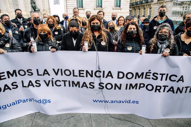 Un grupo de personas, acompañadas por miembros del congreso de los Diputados, sostienen una pancarta en una concentración contra la violencia doméstica, frente al Congreso de los Diputados, a 25 de noviembre de 2021, en Madrid, (España). 