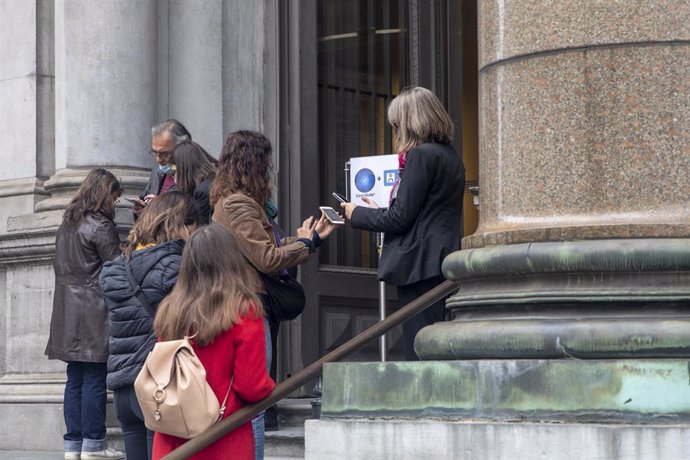 Archivo - 15 October 2021, Belgium, Brussels: People use their mobile phones to run the 'Covid Safe Ticket' app, at the Royal Museums of Fine Arts of Belgium. In Brussels, a Covid Safe Ticket is necessary to enter restaurants, bars, cinemas and fitness 