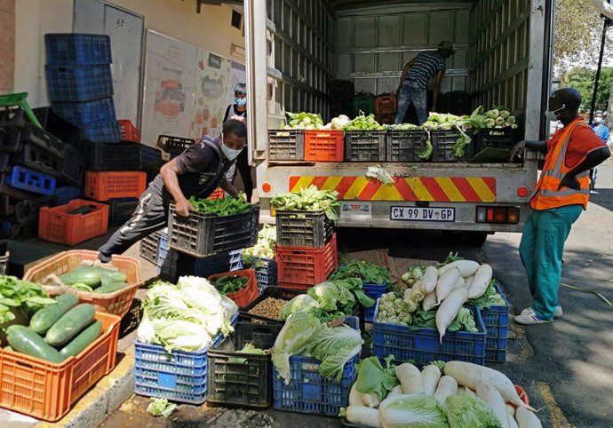 Un grupo de trabajadores descarga un camión en un mercado de Johannesburgo, Sudáfrica.