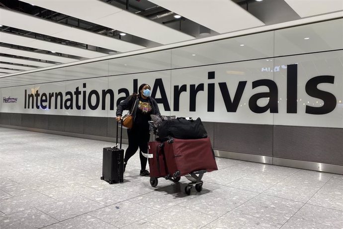Archivo -  Un pasajero empuja un carrito en la sala de llegadas de la Terminal 5 del aeropuerto londinense de Heathrow