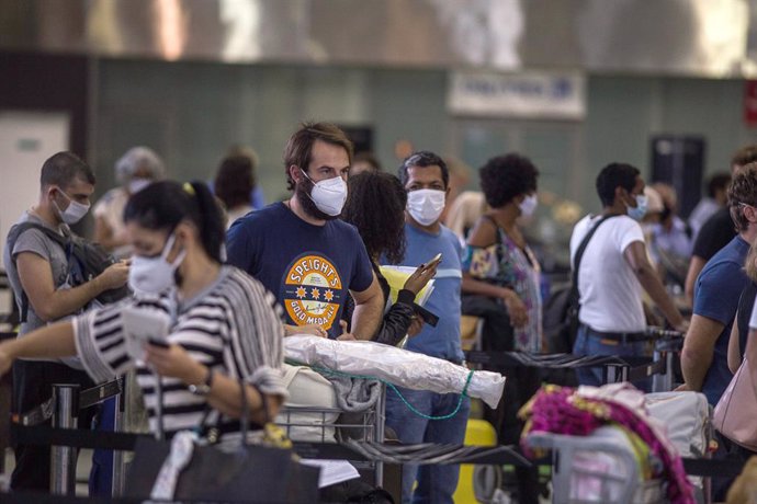 Archivo - 14 January 2021, Brazil, Sao Paulo: Passengers wear face masks as they queue for check-in at Guarulhos International Airport after the British government imposed a ban on arrivals from South America due to a new Covid-19 mutation. Photo: Andre