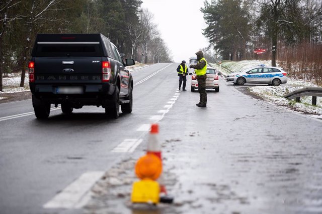 24 November 2021, Poland, Kuznica: A Polish soldier and a police officer check vehicles entering the state of the emergency area near the town of Kuznica on the Polish-Belarusian border. On Thursday, the Polish border guard said there were at least 375 at