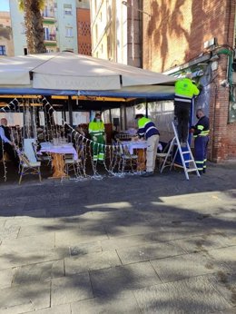 Operarios municipales retiran elementos de la terraza del restaurante Salamanca de la Barceloneta