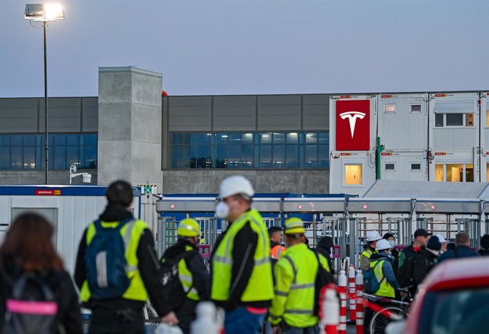 22 November 2021, Brandenburg, Gruenheide: Workers wait at an entrance to the construction site for the future battery factory of the US electric car manufacturer Tesla in Gruenheide near Berlin. 
