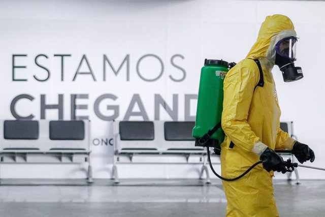 Archivo - 01 July 2020, Brazil, Guarulhos: An agent of the Brazilian Southeast Command Army wears a protective suit takes part in a disinfection process for the GRU Airport as part of the government plan to contain the spread of the Coronavirus (COVID-19)