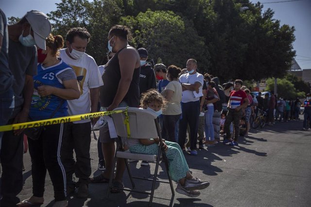 Archivo - Migrantes hacen fila en el cruce fronterizo de El Chaparral para recibir su vacuna contra la COVID-19