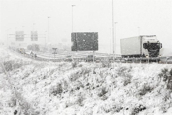 Archivo - Un camión circula por una autovía nevada en Burgos, Castilla y León (España), a 8 de marzo de 2021. La nieve ha sorprendido a los burgaleses este lunes desde primera hora de la mañana, a pesar de que no había aviso en las previsiones meteoroló