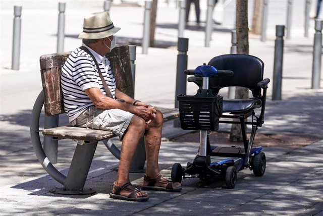 Archivo - Un anciano con mascarilla sentado en un banco, a 27 de julio de 2021, en Madrid, (España).