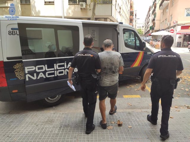 Archivo - El hombre acusado de incendiar contenedores en Palma, escoltado por la Policía cuando fue detenido en julio de 2020.