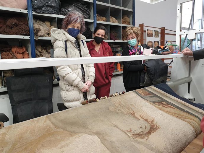 La consejera Rebeca Esnaola observa el trabajo que se realiza en uno de los tapices del Gobierno de Navarra