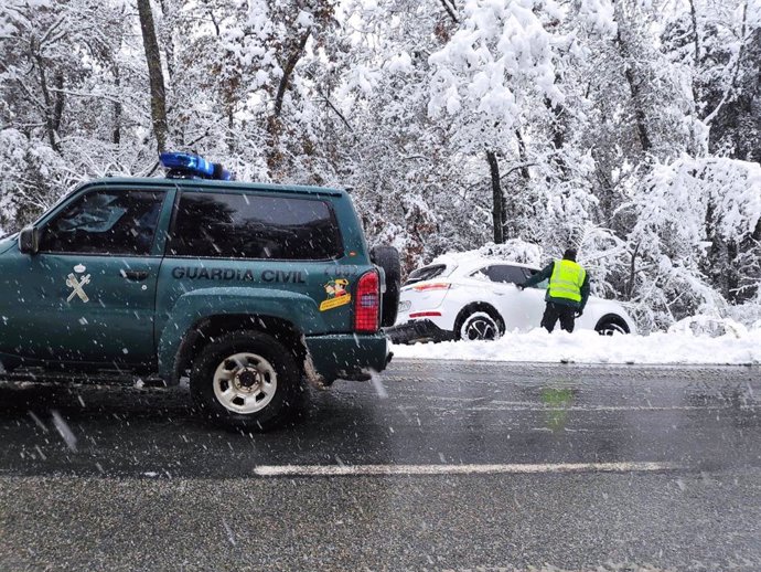 Un agente de la Guardia Civil atiende un accidente de tráfico como consecuencia de la nieve