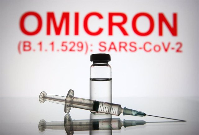26 November 2021, Ukraine, ---: An illustration photo shows a medical syringe and a vial in front of the text Omicron (B.1.1.529): SARS-CoV-2 in the background.