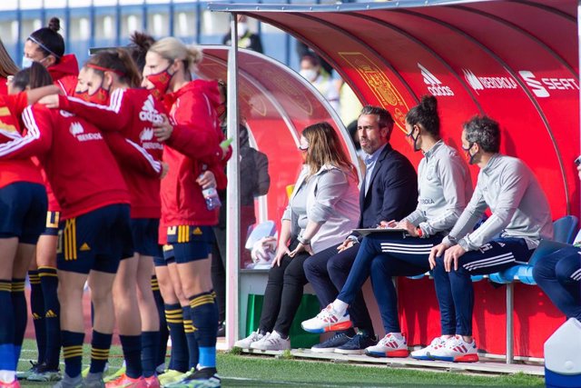 Archivo - Jorge Vilda sentado en el banquillo mientras las jugadoras de la selección española hacen una piña antes de un partido