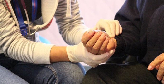 Archivo - Una persona mayor recibe ayuda.